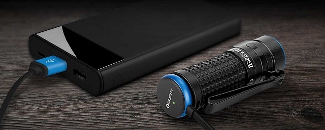 picture of a torch connected to a charger on a wooden surface