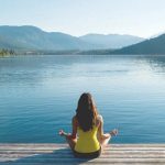 woman meditating on a lake