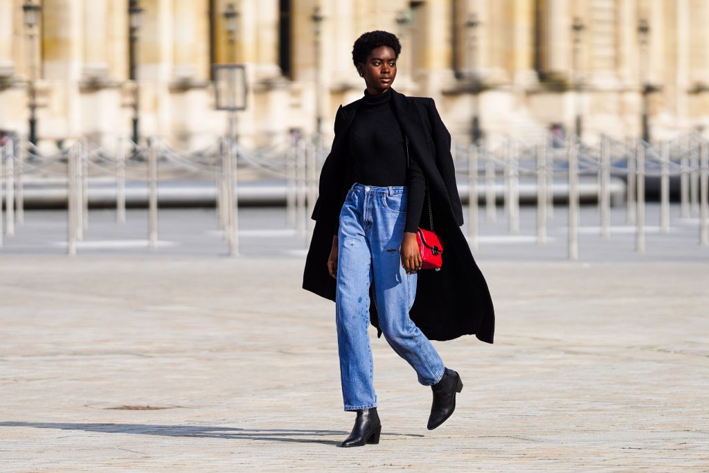 a woman wearing a black bodysuit paired with mom jeans

