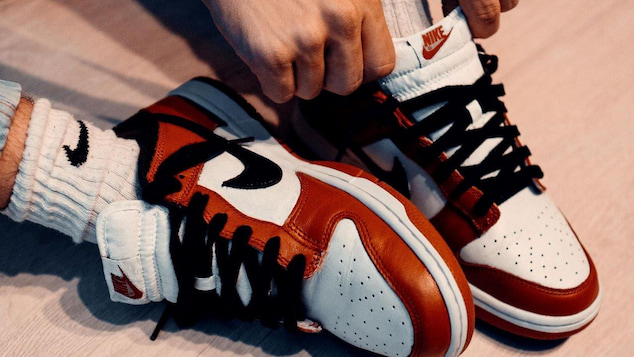 person tying the laces on their nike dunks
