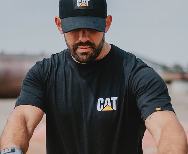 man wearing CAT workwear, shirt, and cap