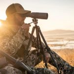 man using spotting telescope